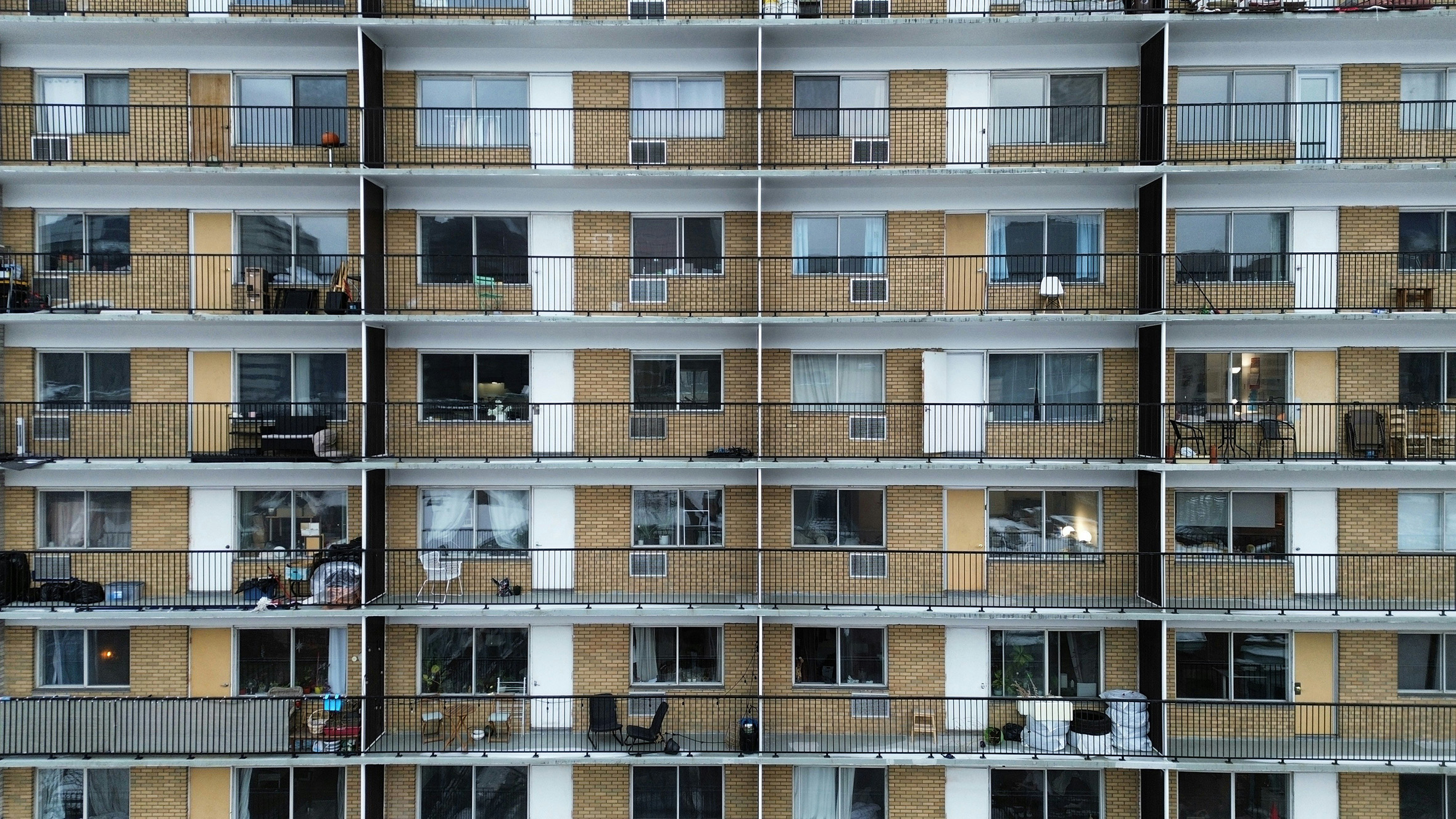 Apartment building facade with rows of balconies and windows